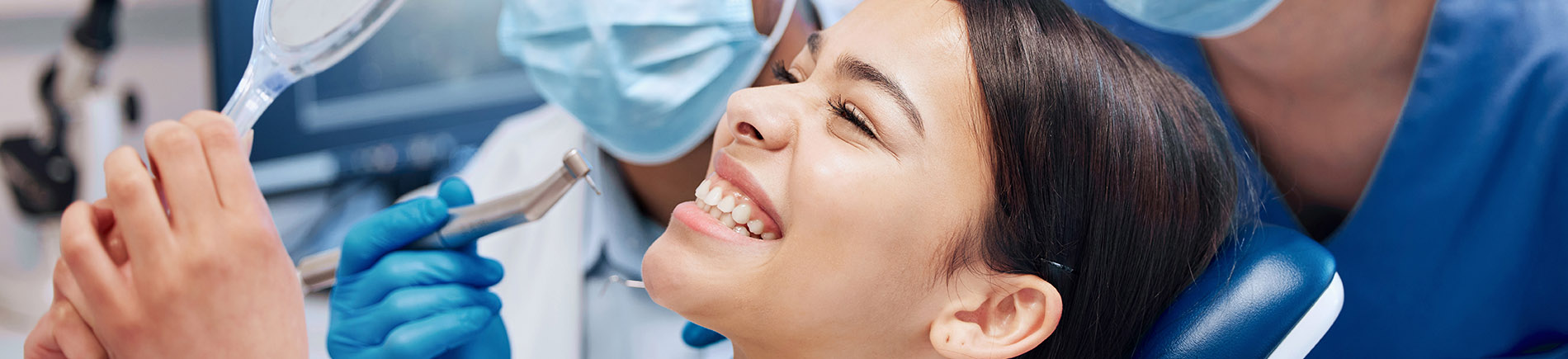 A well-lit reception area with a desk, computer monitor, and potted plant.
