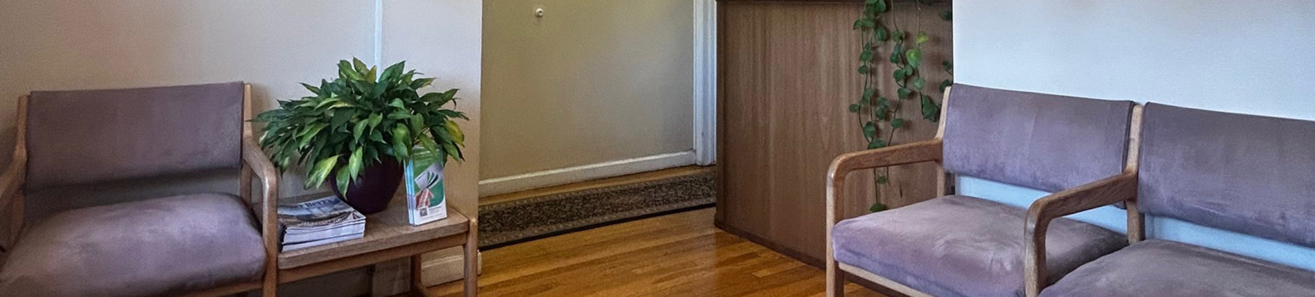 The image shows two different views of an interior space featuring a waiting area with a brown couch, a potted plant, and a chair.